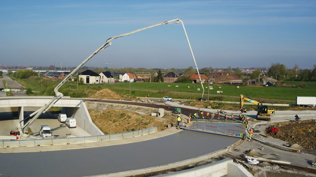 Pompe à béton de 60 m de flèche alimentant le coulage de l’anneau du pont giratoire de la Route de la Laine à Mouscron