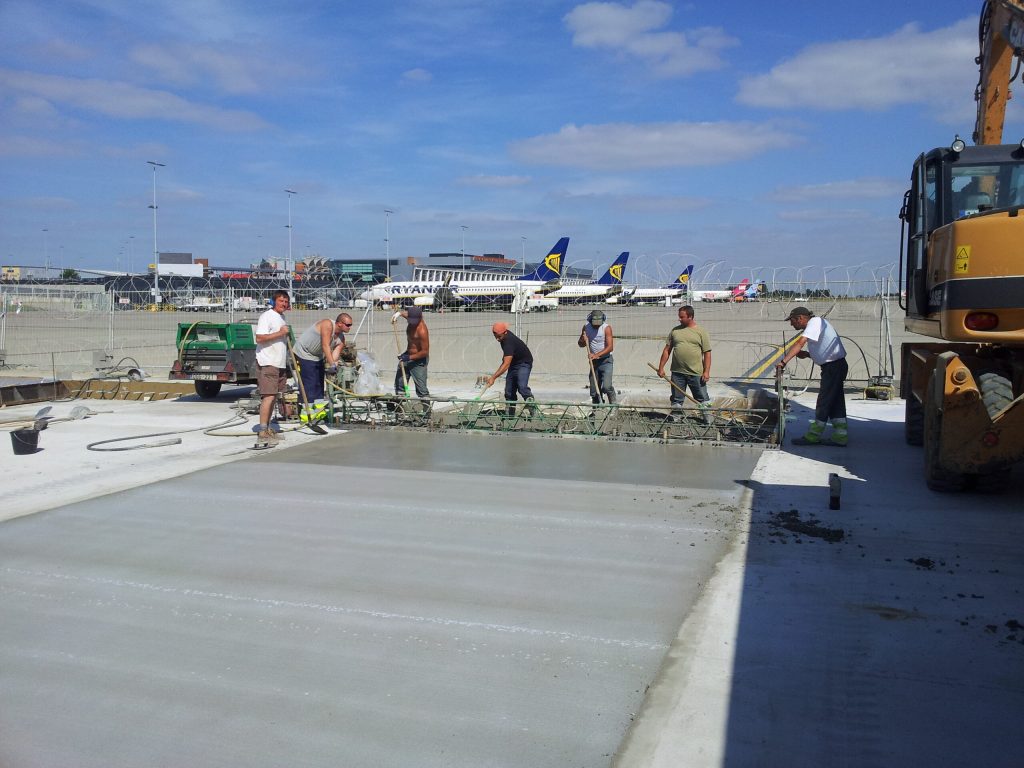 Équipe TRBA lissant une dalle de béton sur le tarmac de l’aéroport de Charleroi